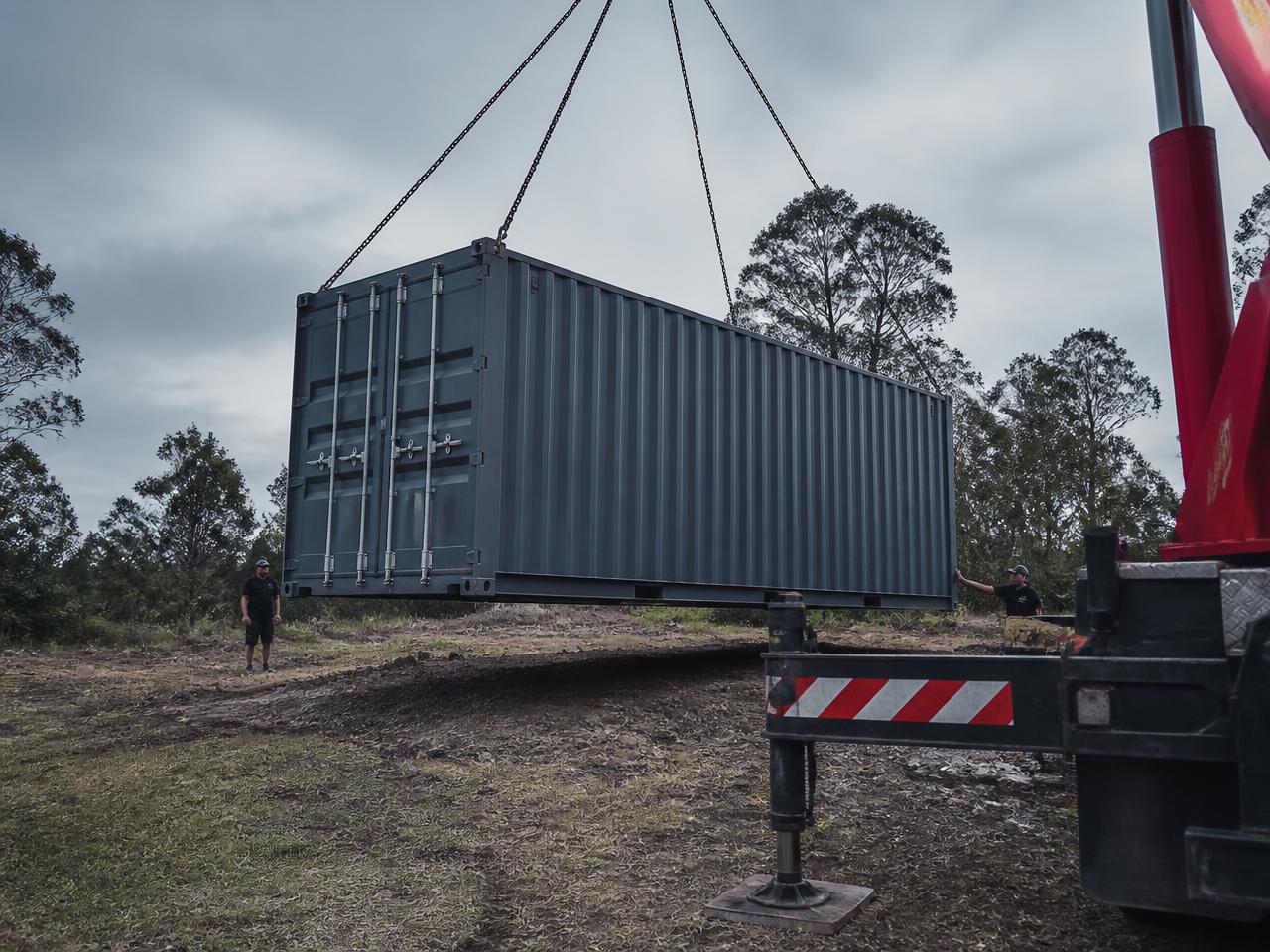 20 ft sea container suspended on crane chains during container transport