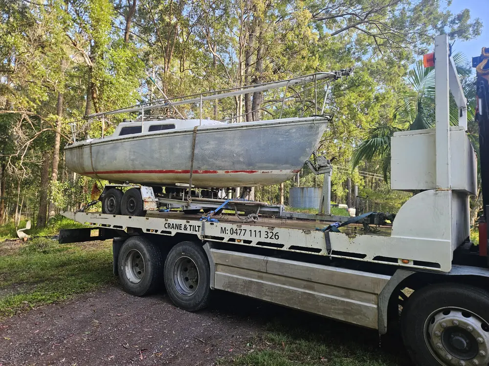 Boat and trailer secured on a tilt tray truck