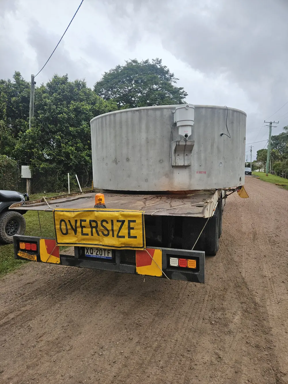 Large cylindrical tank carried on the tilt tray truck