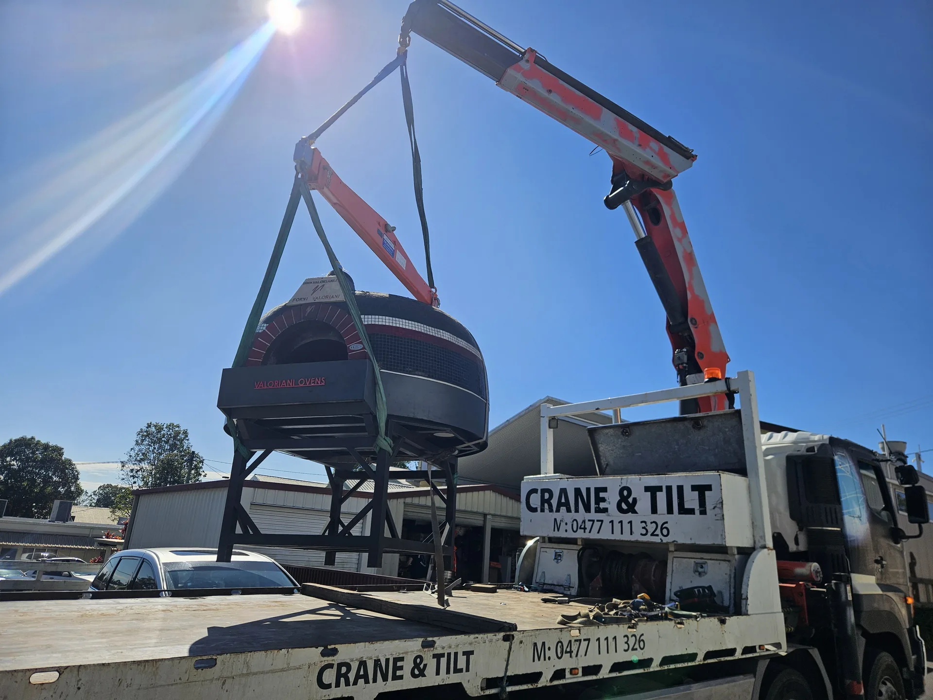 Crane truck lifting a large spa or pod-shaped load
