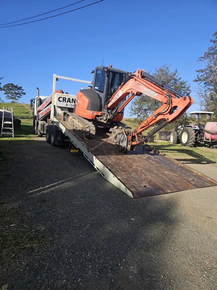 Excavator loading onto tilt tray