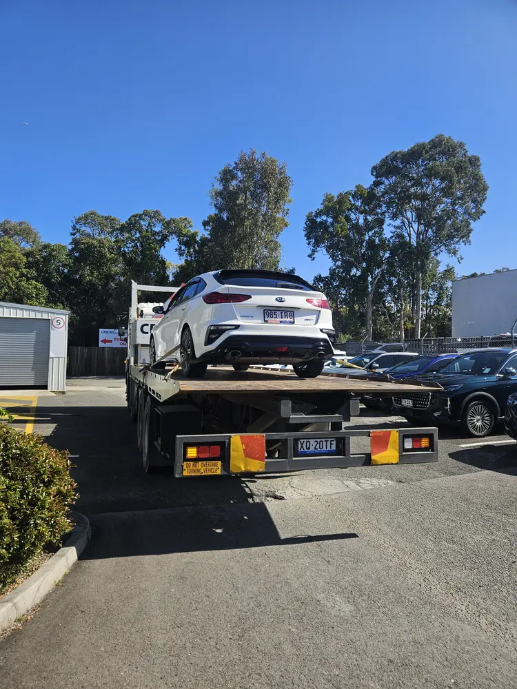 White vehicle carried on tilt tray